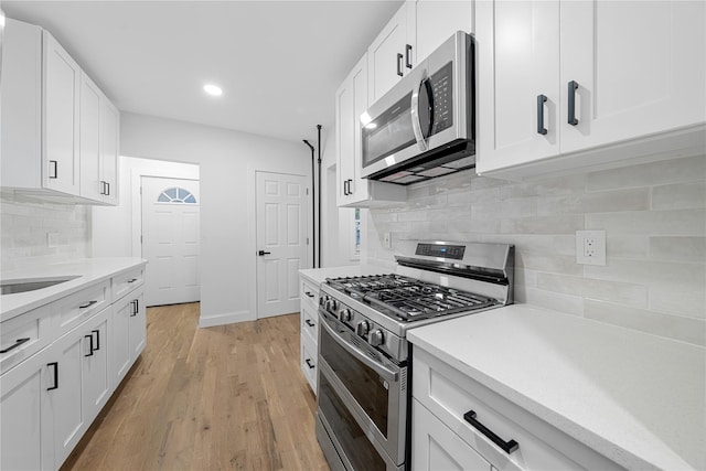 163 Grant Ave, Mineola, NY 11501 - kitchen featuring stainless steel appliances, backsplash, light countertops, white cabinetry, and recessed lighting