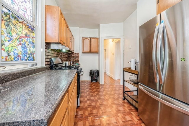 845 Kinsella St, Bronx, NY 10462 - kitchen featuring freestanding refrigerator, gas stove, dark countertops, decorative backsplash, and under cabinet range hood
