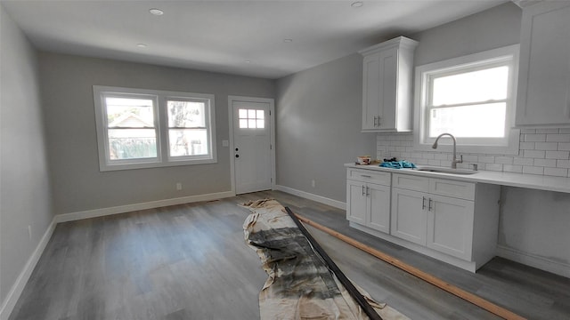 117-36 165th St, Jamaica, NY 11434 - kitchen with light countertops, decorative backsplash, white cabinets, and light wood finished floors