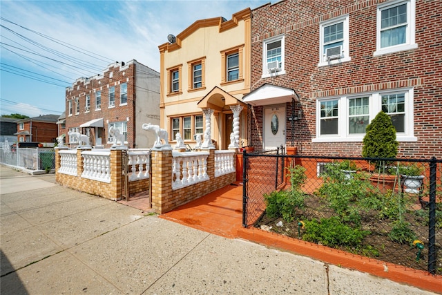 31-30 100th St, East Elmhurst, NY 11369 - view of front facade featuring a fenced front yard, brick siding, and cooling unit