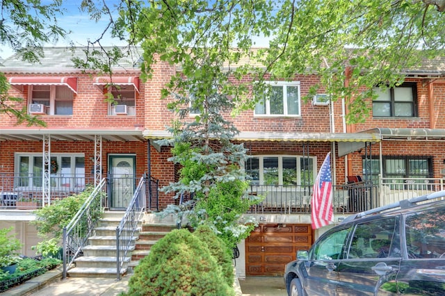 25-27 76th St, Jackson Heights, NY 11370 - view of property featuring brick siding, cooling unit, and an attached garage