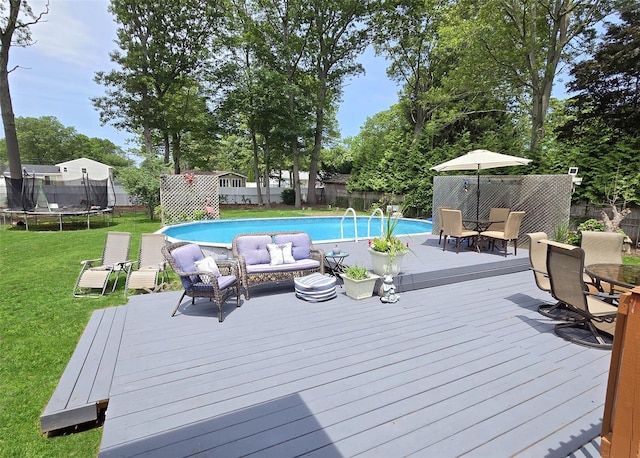 341 Thrift St, Ronkonkoma, NY 11779 - view of swimming pool featuring a trampoline, a wooden deck, and a fenced backyard