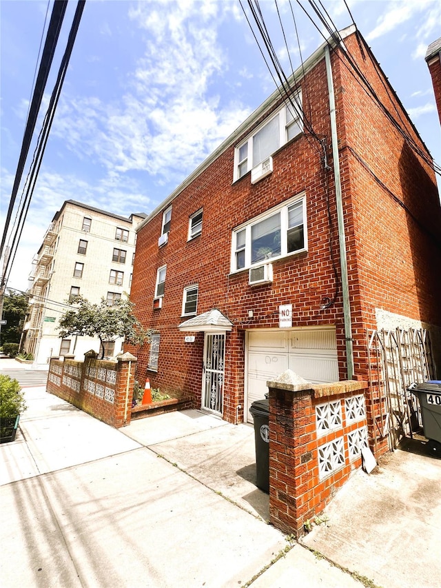 40-03 56th St, Woodside, NY 11377 - view of property with an attached garage, concrete driveway, and cooling unit
