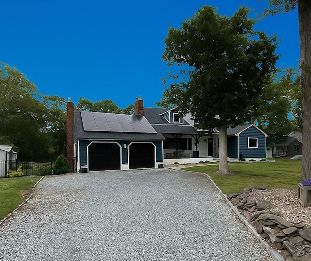 17 Woodcrest Dr, East Moriches, NY 11940 - view of front of house featuring gravel driveway, solar panels, an attached garage, and a chimney