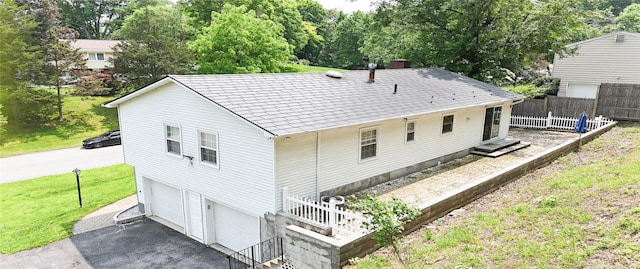 11 Boxwood Close, Hopewell Junction, NY 12533 - rear view of property with an attached garage, a chimney, driveway, and view of wooded area