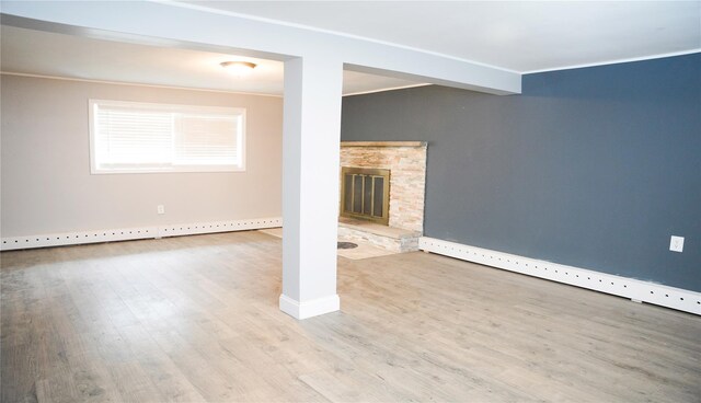 11 Boxwood Close, Hopewell Junction, NY 12533 - unfurnished living room with wood finished floors, a stone fireplace, a baseboard radiator, and crown molding