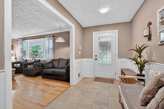 8 Argow Pl, Nanuet, NY 10954 - entryway featuring a textured ceiling, wainscoting, light tile patterned floors, and a decorative wall