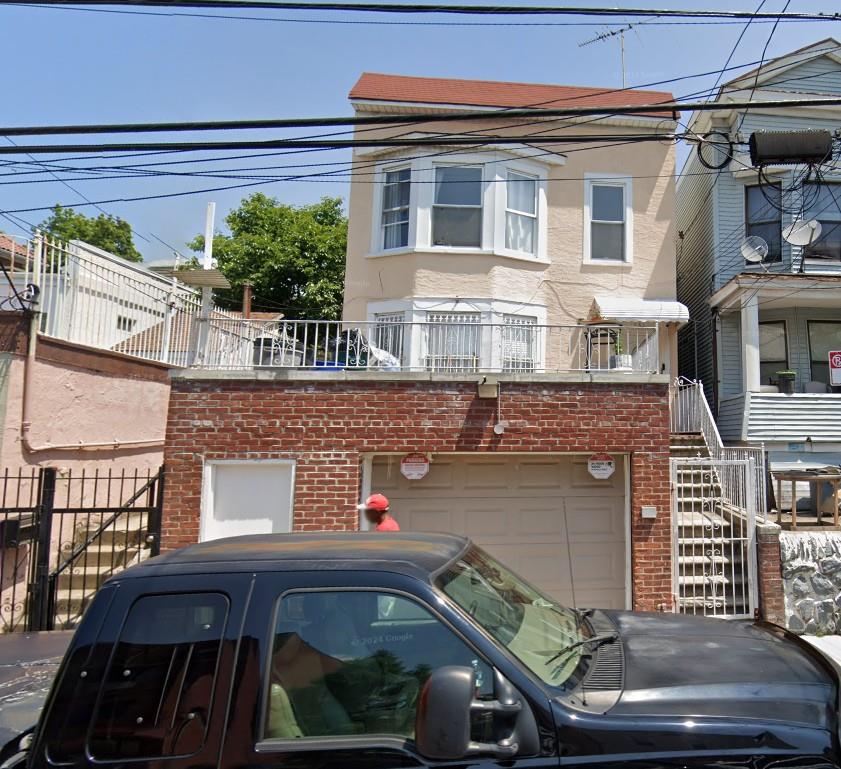761 E 219th St, Bronx, NY 10467 - view of front facade with brick siding, an attached garage, and stucco siding