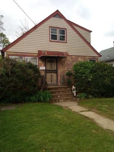 38 Allers Blvd, Roosevelt, NY 11575 - bungalow-style home featuring a front lawn and stone siding