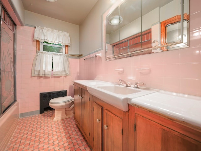 19 E Orchard St, Nanuet, NY 10954 - full bathroom featuring vanity, tile walls, radiator heating unit, and shower / bath combination with glass door