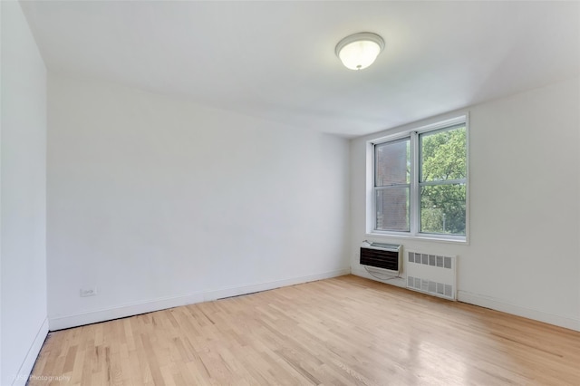46-01 39th Ave Unit 303, Sunnyside, NY 11104 - spare room featuring radiator, wood finished floors, heating unit, and a wall mounted AC