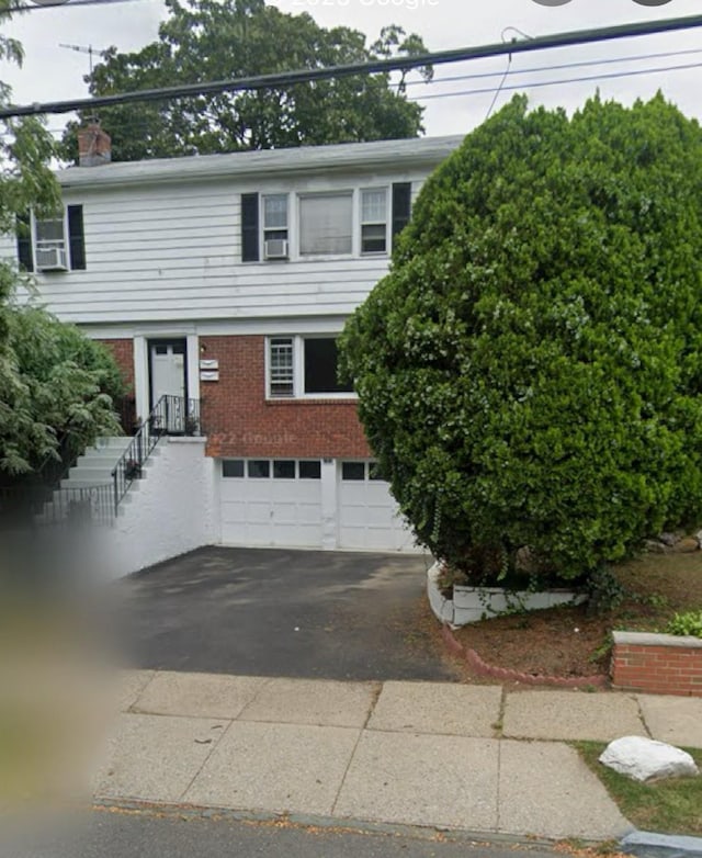 401 E 4th St, Mount Vernon, NY 10553 - view of front facade with driveway, a garage, a chimney, and brick siding