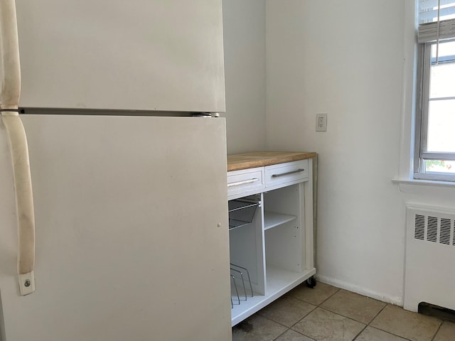 180 Pinewood Dr Unit 11, Hartsdale, NY 10530 - kitchen view of freestanding refrigerator, radiator, and white cabinetry