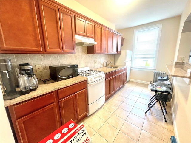 7863 79th Ln, Glendale, NY 11385 - kitchen with white appliances, under cabinet range hood, radiator heating unit, decorative backsplash, and light stone counters