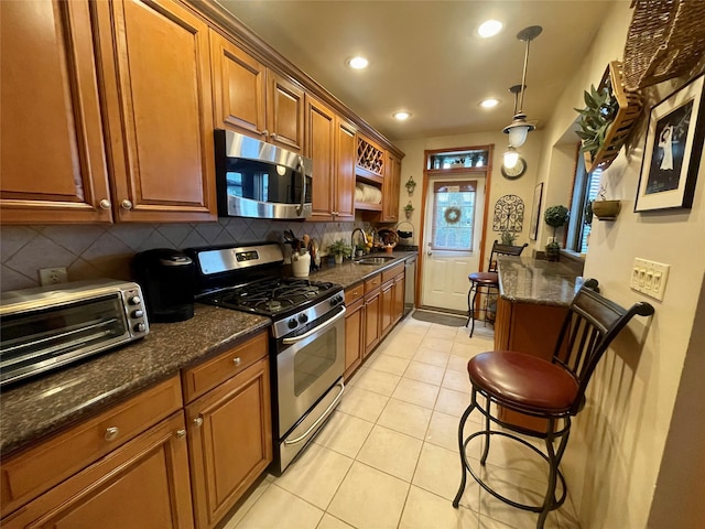 7863 79th Ln, Glendale, NY 11385 - kitchen with stainless steel appliances, tasteful backsplash, recessed lighting, brown cabinets, and light tile patterned flooring