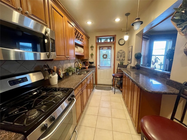 7863 79th Ln, Glendale, NY 11385 - kitchen with stainless steel appliances, brown cabinetry, decorative backsplash, light tile patterned floors, and recessed lighting