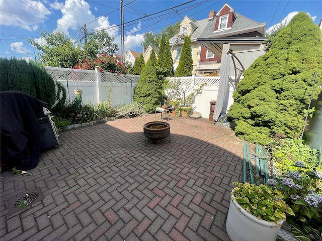 7863 79th Ln, Glendale, NY 11385 - fenced backyard featuring a patio, an outdoor fire pit, and a grill