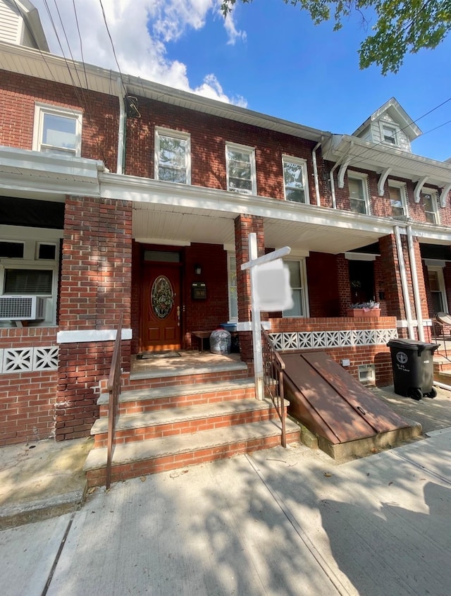 7863 79th Ln, Glendale, NY 11385 - townhome / multi-family property featuring brick siding, cooling unit, and covered porch