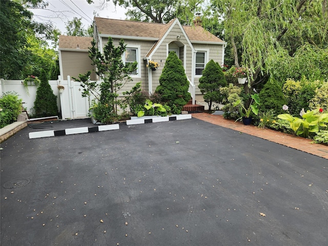 26 Long Beach Dr, Sound Beach, NY 11789 - view of front of property featuring uncovered parking, a chimney, and a shingled roof