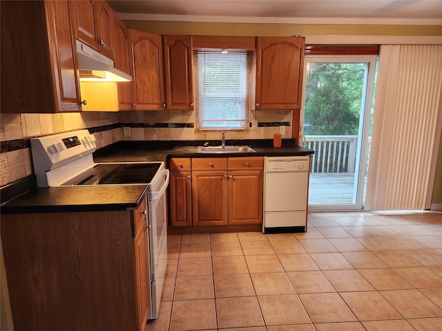 26 Long Beach Dr, Sound Beach, NY 11789 - kitchen with under cabinet range hood, white appliances, dark countertops, decorative backsplash, and plenty of natural light