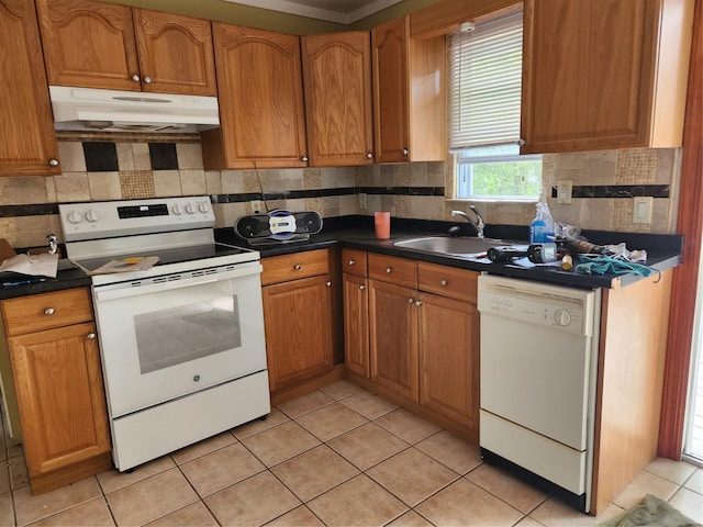 26 Long Beach Dr, Sound Beach, NY 11789 - kitchen featuring white appliances, under cabinet range hood, dark countertops, brown cabinetry, and light tile patterned flooring