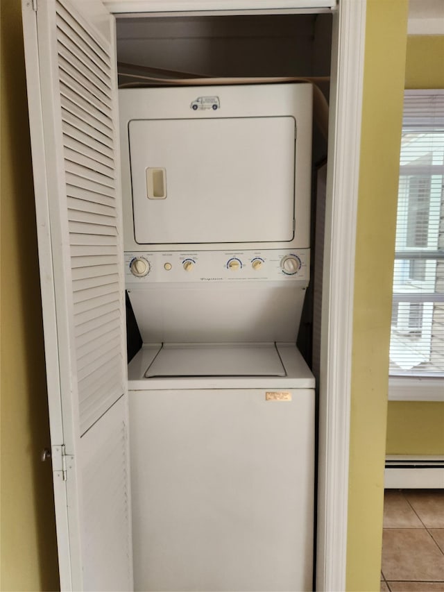 26 Long Beach Dr, Sound Beach, NY 11789 - washroom featuring stacked washer / dryer, a baseboard radiator, and tile patterned flooring