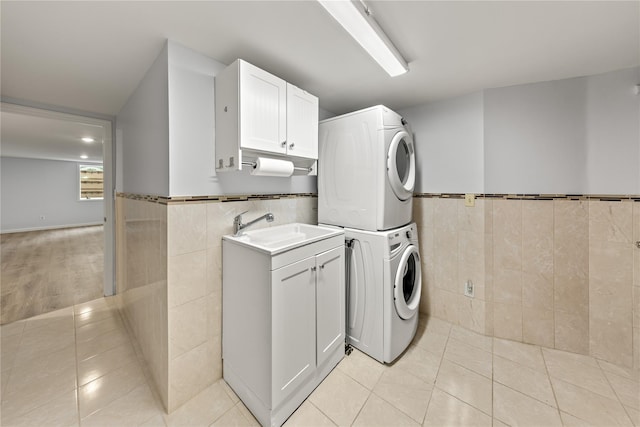 162 Airport Rd, New Hampton, NY 10958 - washroom with stacked washer and clothes dryer, tile walls, light tile patterned floors, a wainscoted wall, and cabinet space