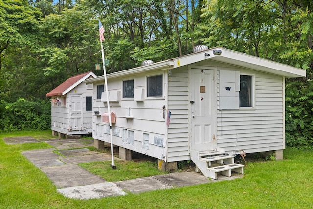 162 Airport Rd, New Hampton, NY 10958 - view of side of property featuring a lawn, view of wooded area, and an outdoor structure