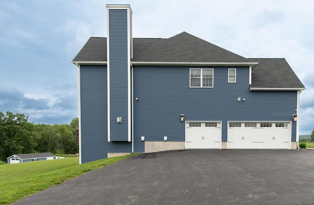 45 Jeffrey Dr, Pleasant Valley, NY 12569 - view of side of home featuring a chimney, a shingled roof, a yard, asphalt driveway, and an attached garage