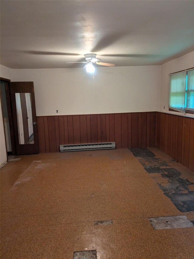 24 Delilah Ln, Plattekill, NY 12589 - carpeted empty room with a baseboard heating unit, wainscoting, wood walls, and ceiling fan