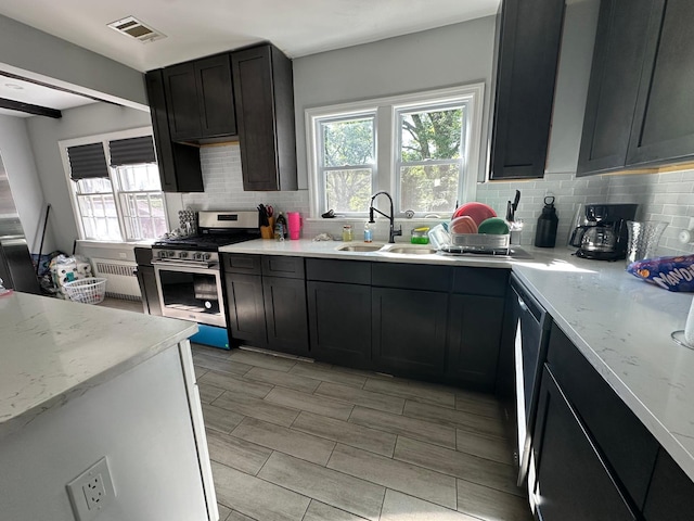 627 Haverstraw Rd, Airmont, NY 10901 - kitchen with stainless steel range with gas cooktop, backsplash, plenty of natural light, and light stone counters