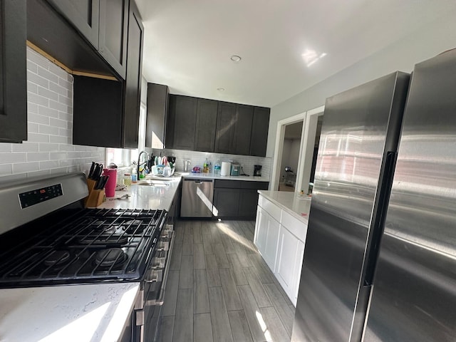 627 Haverstraw Rd, Airmont, NY 10901 - kitchen with appliances with stainless steel finishes, tasteful backsplash, wood finish floors, and light stone countertops