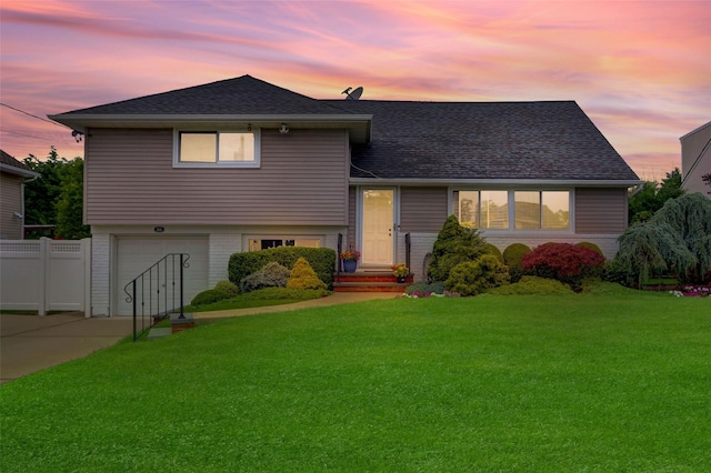 318 W Cortland Ave, Oceanside, NY 11572 - tri-level home featuring an attached garage, driveway, roof with shingles, and brick siding