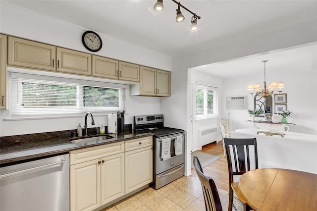 318 W Cortland Ave, Oceanside, NY 11572 - kitchen with appliances with stainless steel finishes, cream cabinetry, radiator, light tile patterned floors, and a chandelier