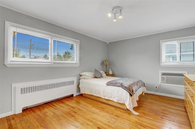 318 W Cortland Ave, Oceanside, NY 11572 - bedroom featuring radiator heating unit, light wood-type flooring, a wall mounted air conditioner, and ornamental molding