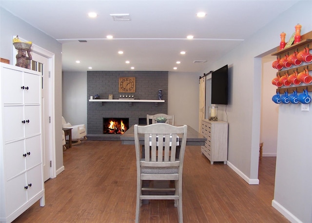 71 Strathmore Village Dr, South Setauket, NY 11720 - dining area with wood finished floors, recessed lighting, a fireplace, and a barn door