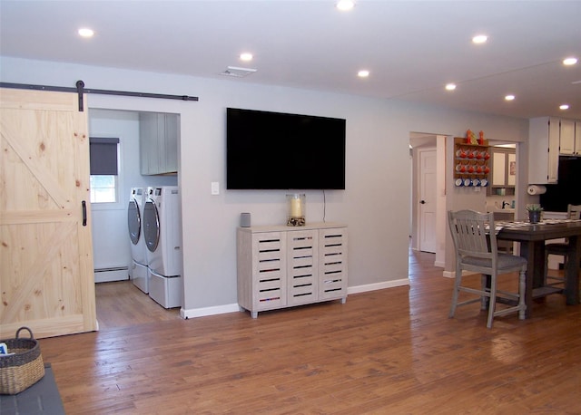 71 Strathmore Village Dr, South Setauket, NY 11720 - living area with washer and dryer, a barn door, wood finished floors, a baseboard radiator, and recessed lighting
