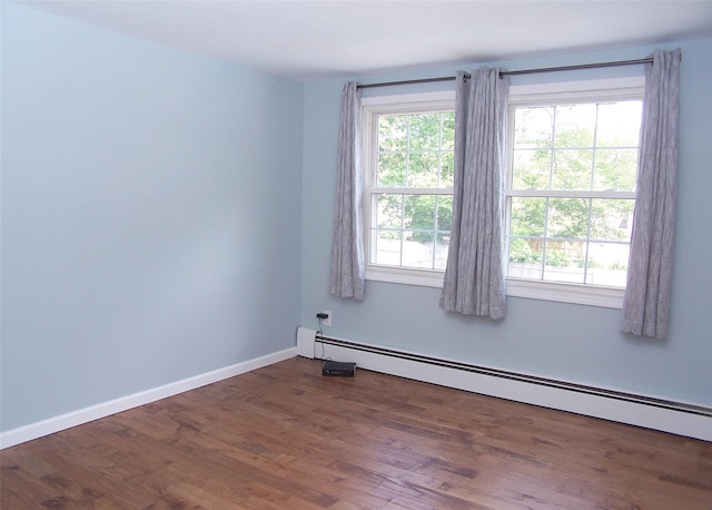 71 Strathmore Village Dr, South Setauket, NY 11720 - empty room featuring a baseboard heating unit, plenty of natural light, and wood finished floors