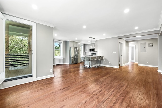 1133 Midland Ave Unit 4E, Bronxville, NY 10708 - unfurnished living room with radiator heating unit, ornamental molding, dark wood-type flooring, recessed lighting, and electric panel