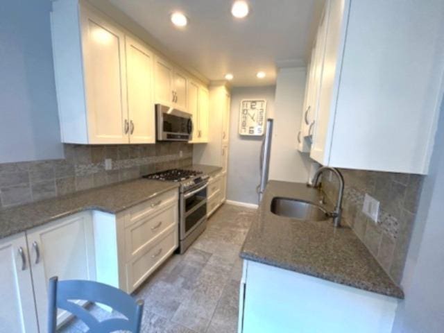257 Cedarhurst Ave Unit A 8, Cedarhurst, NY 11516 - kitchen with appliances with stainless steel finishes, white cabinetry, backsplash, recessed lighting, and dark stone countertops