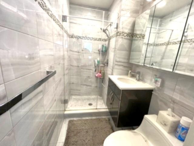 257 Cedarhurst Ave Unit A 8, Cedarhurst, NY 11516 - bathroom featuring tile walls, vanity, and a stall shower