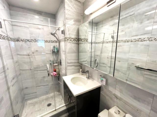 257 Cedarhurst Ave Unit A 8, Cedarhurst, NY 11516 - bathroom with a shower stall, vanity, and tile walls
