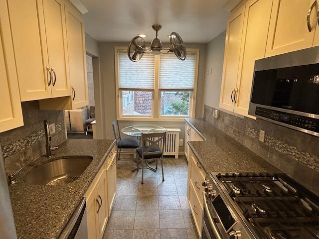 257 Cedarhurst Ave Unit A 8, Cedarhurst, NY 11516 - kitchen with appliances with stainless steel finishes, a chandelier, tasteful backsplash, white cabinets, and dark stone counters