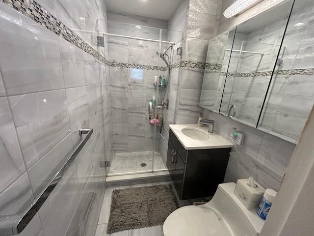257 Cedarhurst Ave Unit A 8, Cedarhurst, NY 11516 - full bathroom featuring tile walls, a stall shower, vanity, and recessed lighting