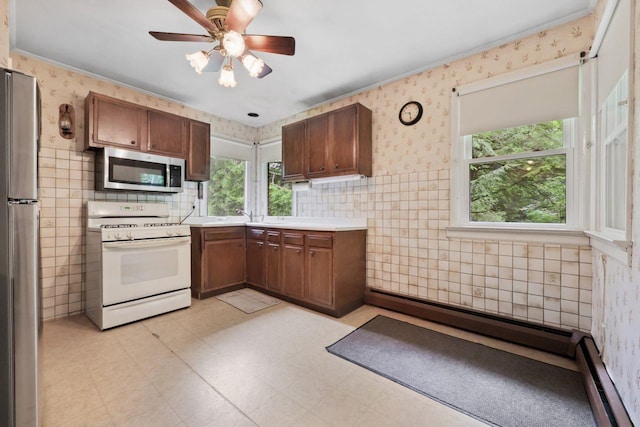65 Hortontown Rd, Carmel, NY 10512 - kitchen featuring stainless steel appliances, tile walls, plenty of natural light, light floors, and a baseboard radiator
