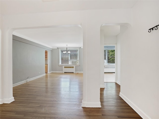 90 Bryant Ave Unit 3Da, White Plains, NY 10605 - spare room with arched walkways, radiator heating unit, a chandelier, dark wood finished floors, and cooling unit