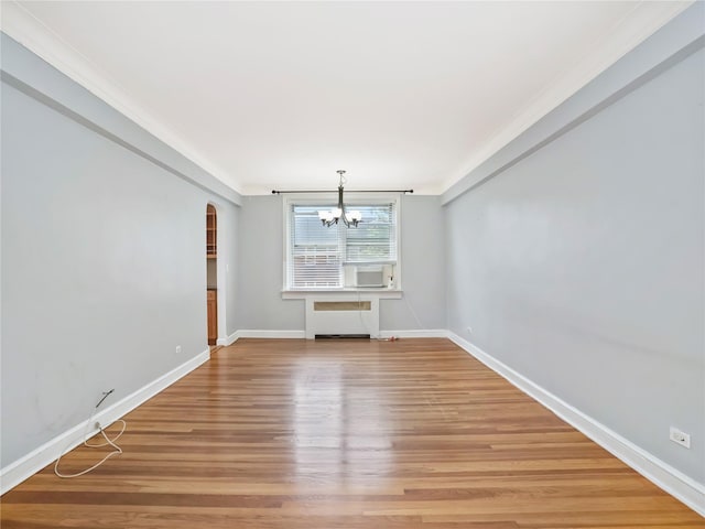 90 Bryant Ave Unit 3Da, White Plains, NY 10605 - unfurnished living room featuring a chandelier, light wood-type flooring, arched walkways, radiator heating unit, and crown molding