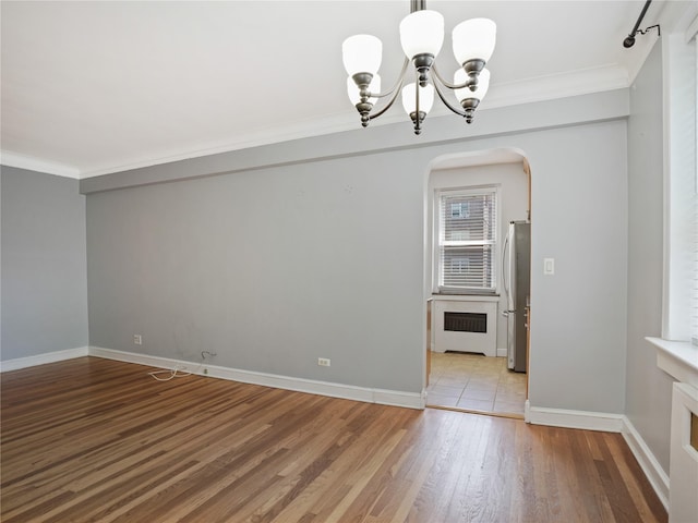 90 Bryant Ave Unit 3Da, White Plains, NY 10605 - unfurnished dining area with a chandelier, ornamental molding, arched walkways, and light wood-style floors