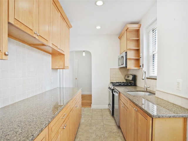 90 Bryant Ave Unit 3Da, White Plains, NY 10605 - kitchen with stainless steel appliances, open shelves, backsplash, light stone countertops, and arched walkways
