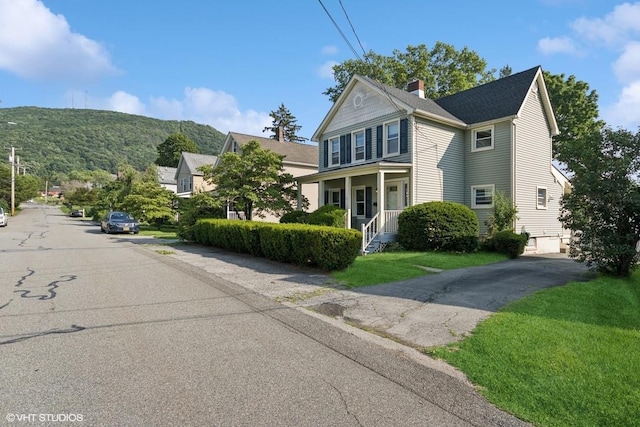 65 Union St, Beacon, NY 12508 - view of front of home with a chimney, covered porch, and a front lawn